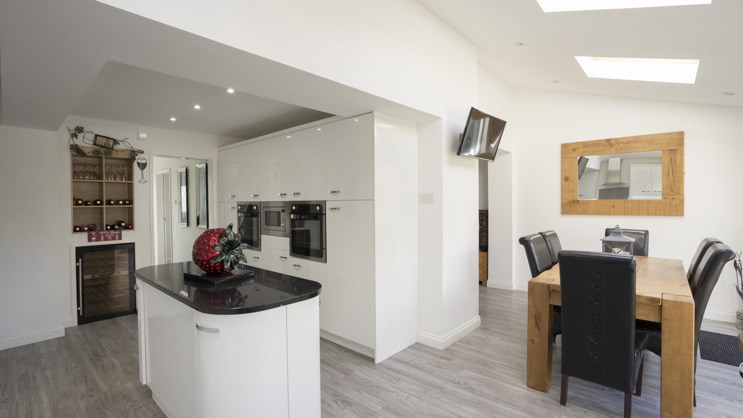 White gloss kitchen supplied with mirror black granite worktops as part of this open plan re-model.