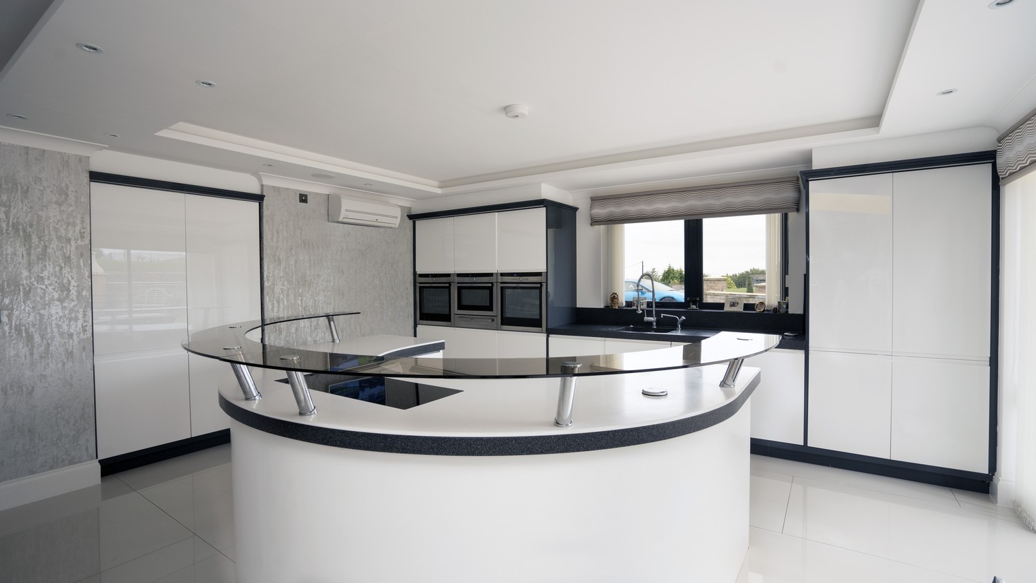 Gloss White Handle-less kitchen supplied and fitted in Aughton, Liverpool. This kitchen featuring a circular island at the center fo the kitchen a great space for both entertaining and dining.