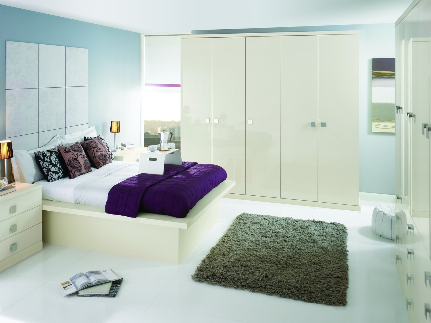 A modern gloss fitted bedroom furniture set finished in Oyster gloss with a modern square chrome handle. The bedroom set features a range of wardrobes and drawers, bed side cabinets and matching bed. This bedroom has added plenty of storage space to this medium sized bedroom, giving plenty of space for the home owners clothes and belongings.