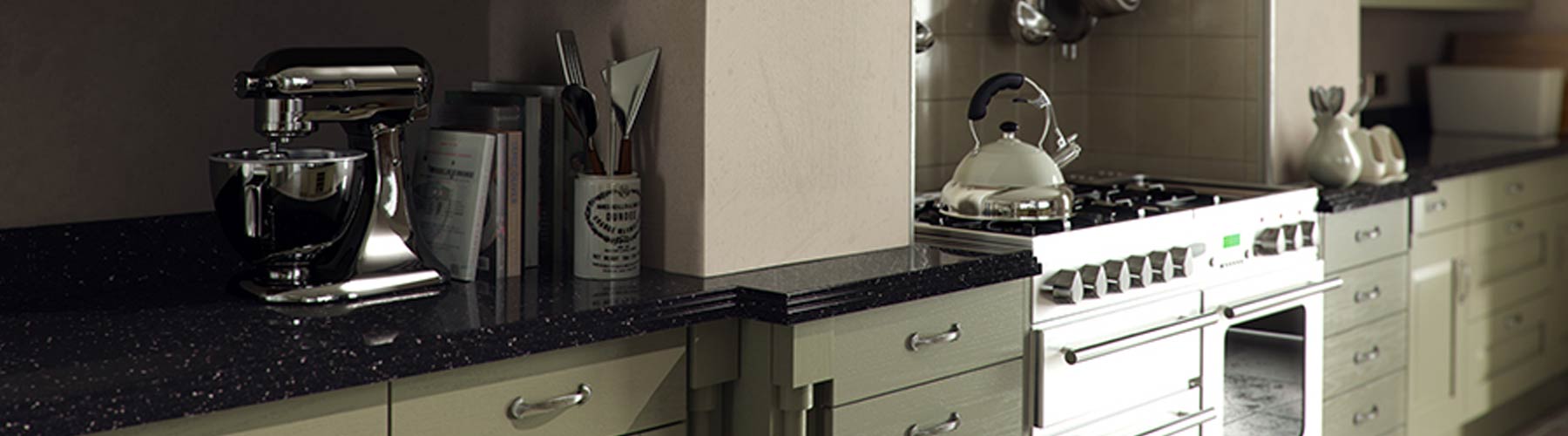 A green traditional kitchen with black worktops and a stainless steel large cooker.