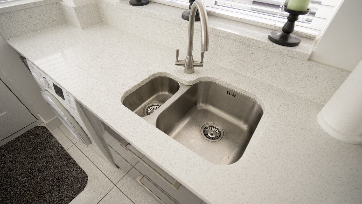 Stainless steel sink and tap, the sink has been under-mounted to the worktop which has been pre-cut in our Kirkby factory.