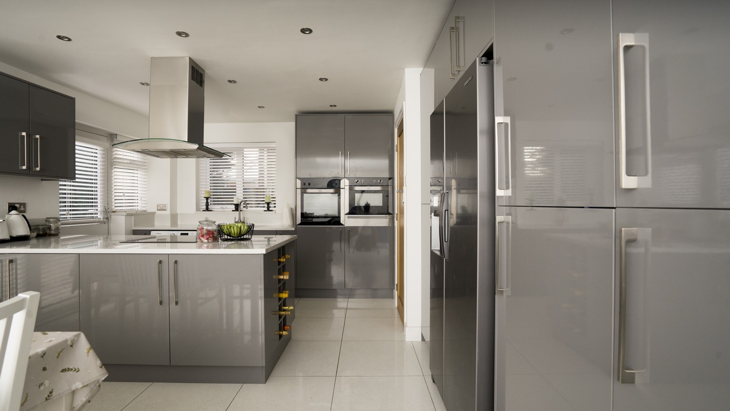 Grey gloss wine racks have also been installed in this family kitchen as shown at the end of the island.