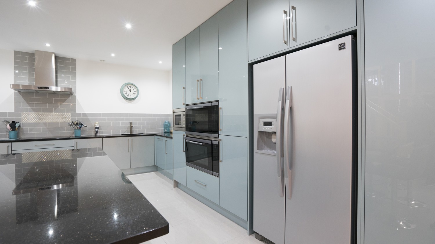 Floor to ceiling feature larder units with integrated appliances and large fridge/freezer.