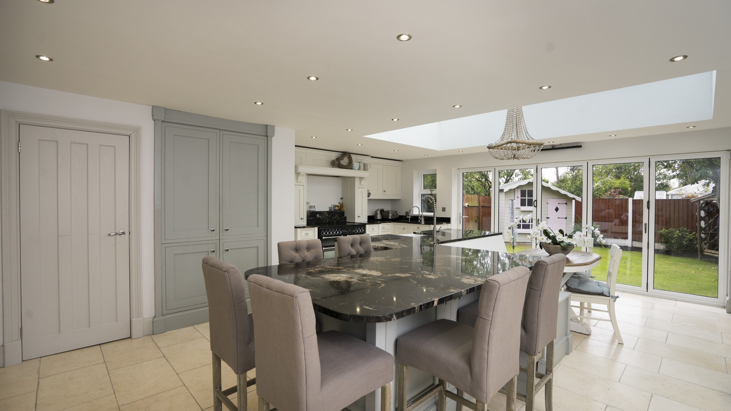 Full overview of this stunning open plan kitchen with roof lantern and bi-folding doors. This kitchen maximises on light, seating, space and all the modern appliance.