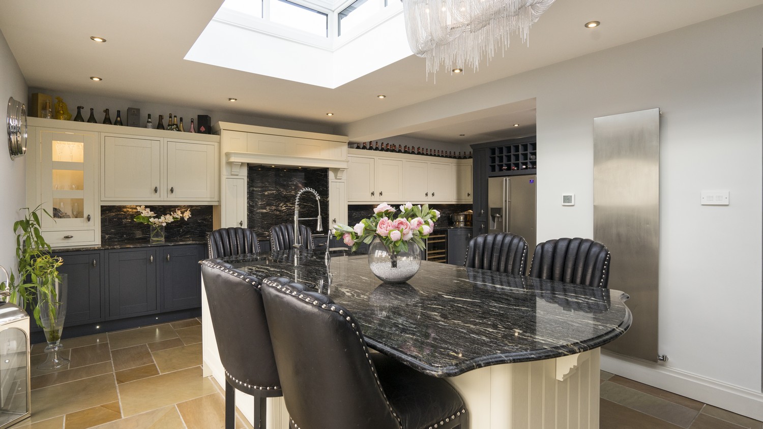 Full image of Ormskirk kitchen with large island used for both dining and preparing food, feature mantel and a wide range of cupboards and draws giving lots of storage.