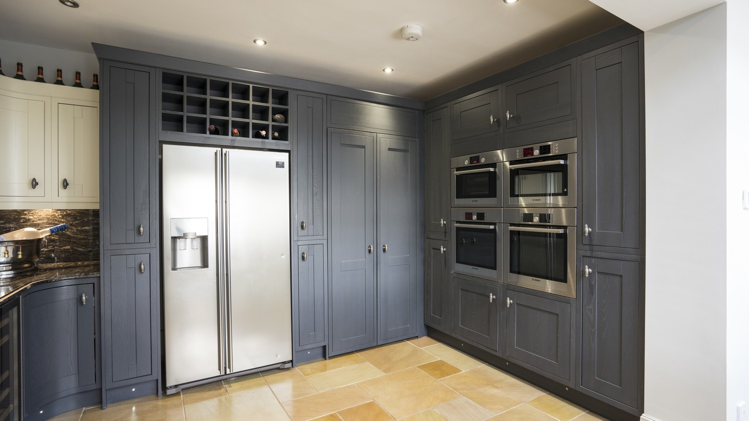 Close up of the larder cupboard housing the various built in appliances, wine rack and hidden entry to the utility room.
