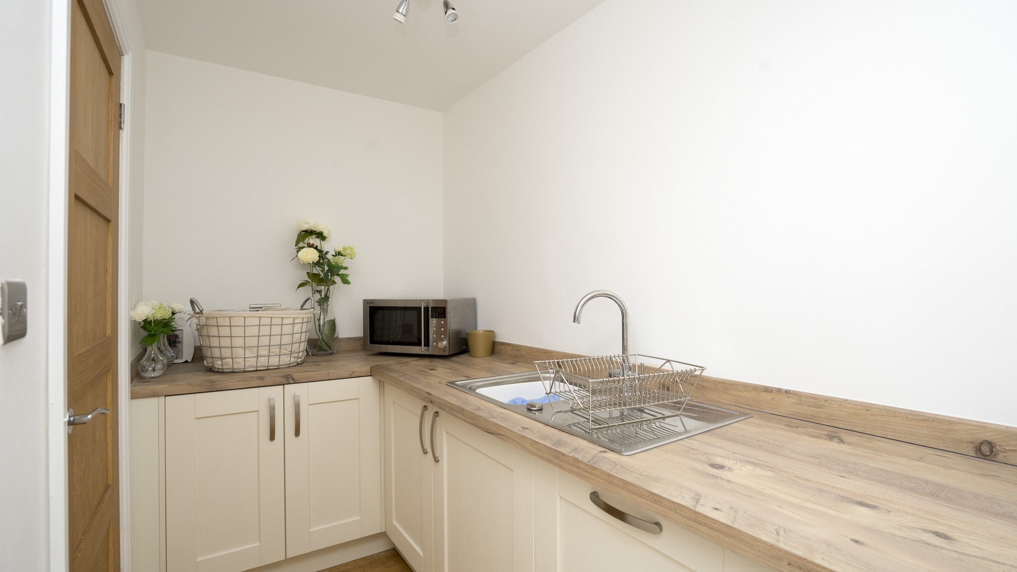 Image of the utility room fitted out with matching cabinets and composite worktops.