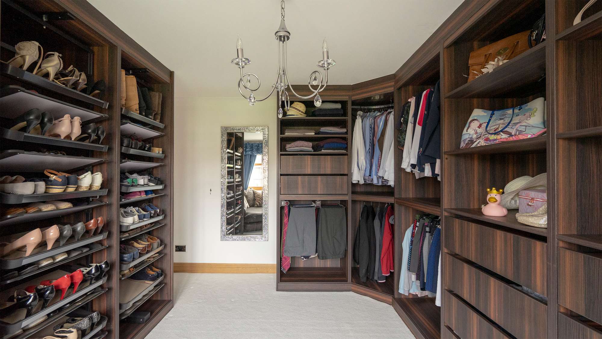 Image showing most of the walk-in wardrobe with the rotating shoe racks on the left side and clothes storage on the right.